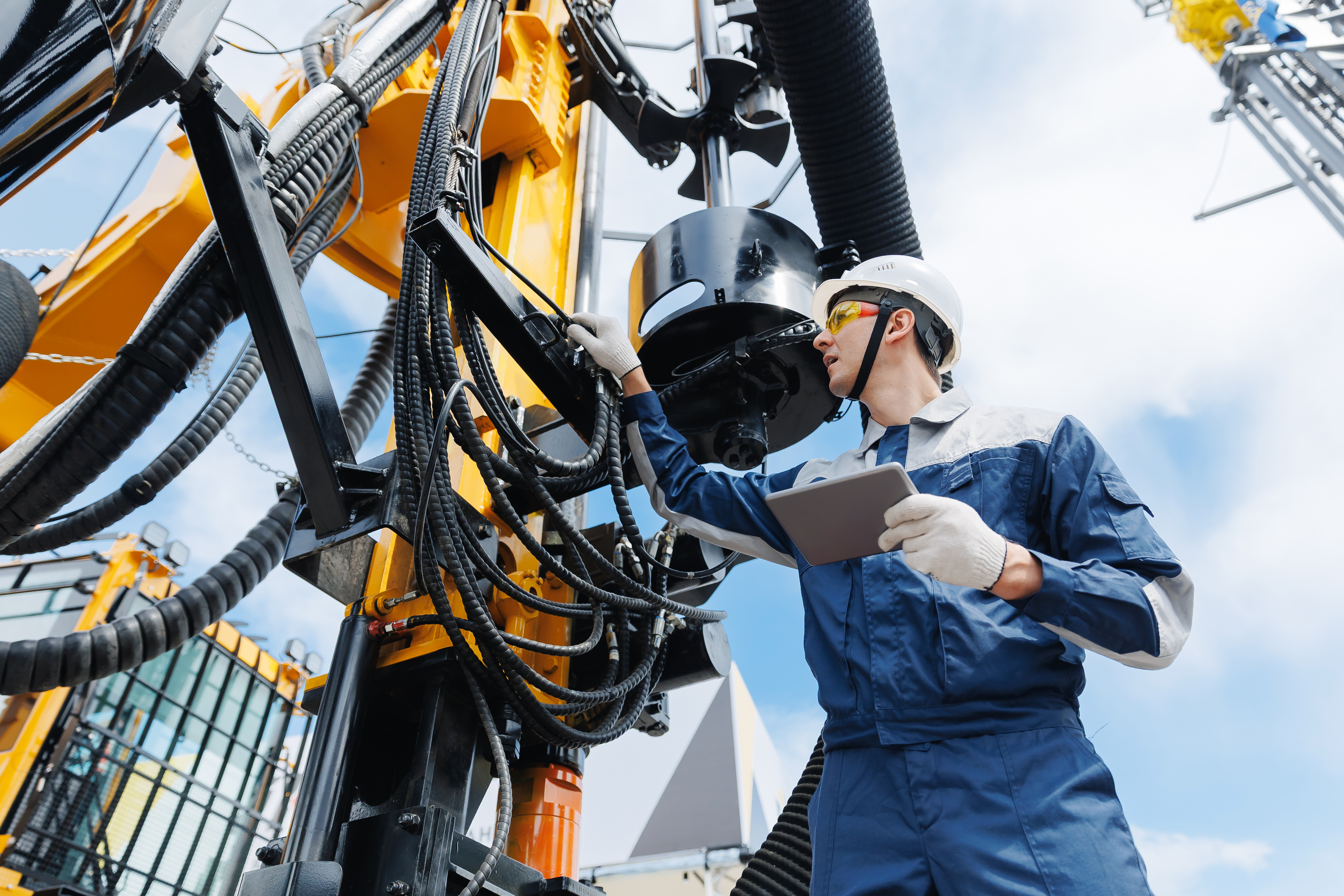 Safety inspector in hard hat reviewing equipment on industrial platform